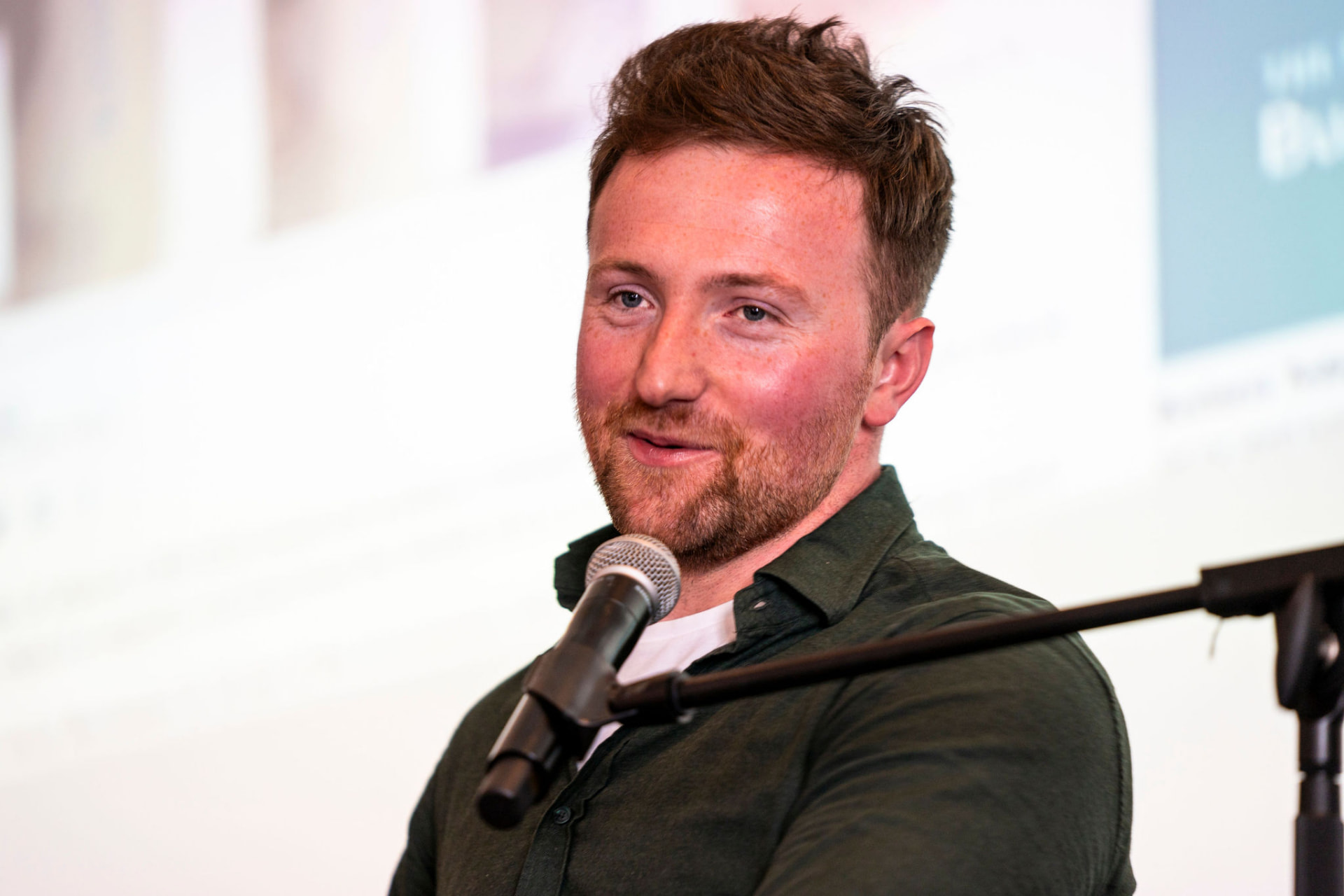 Colin Judge speaking at a microphone during a corporate event